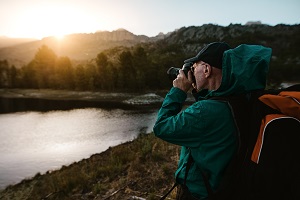 Wetterbedingungen bei Naturfotografie: Mann fotografiert Sonnenaufgang in den Bergen Wetterbedingungen bei Naturfotografie: Mann fotografiert Sonnenaufgang in den Bergen